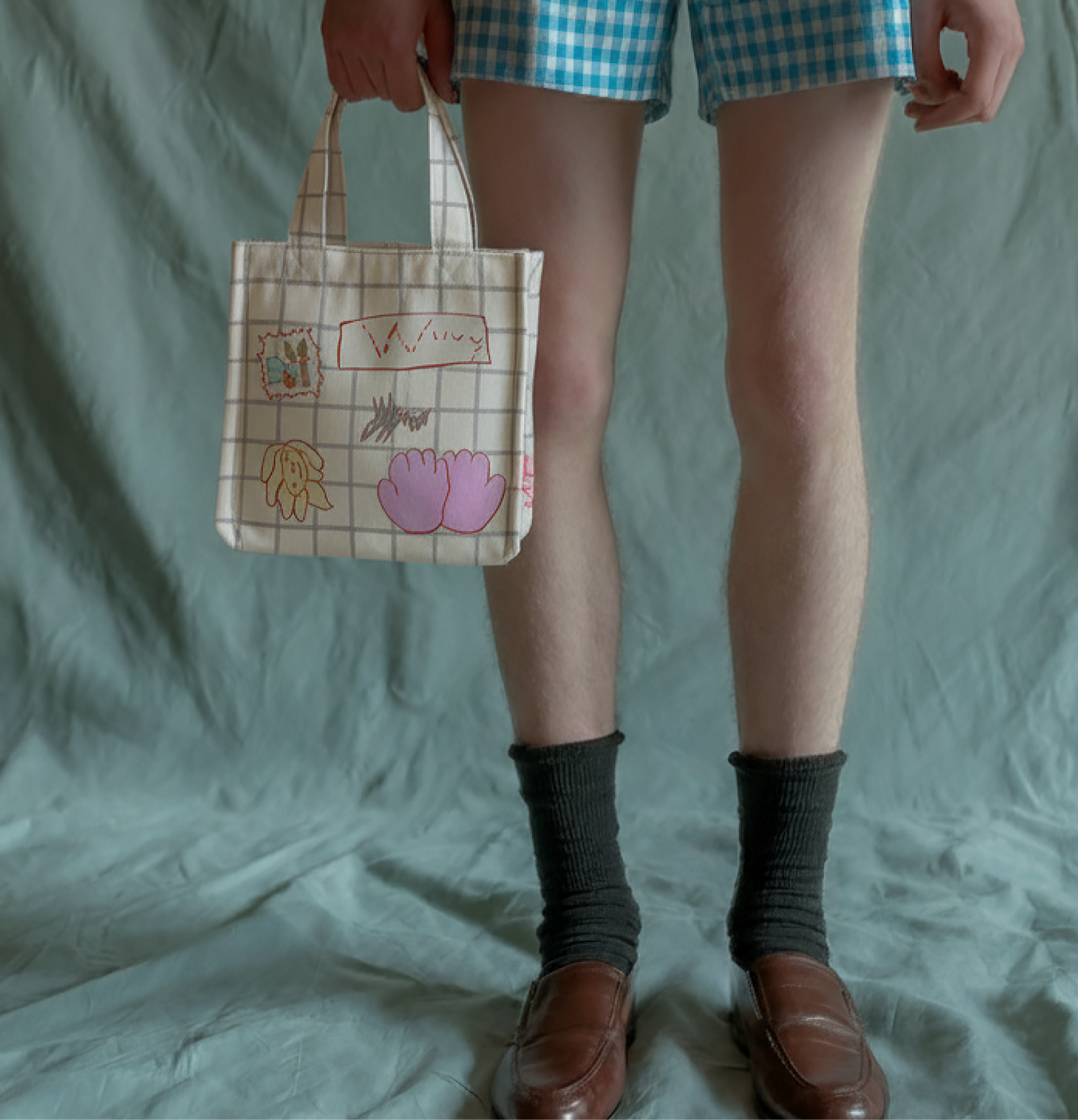 A person holding a hand-finished FRAY textile bag